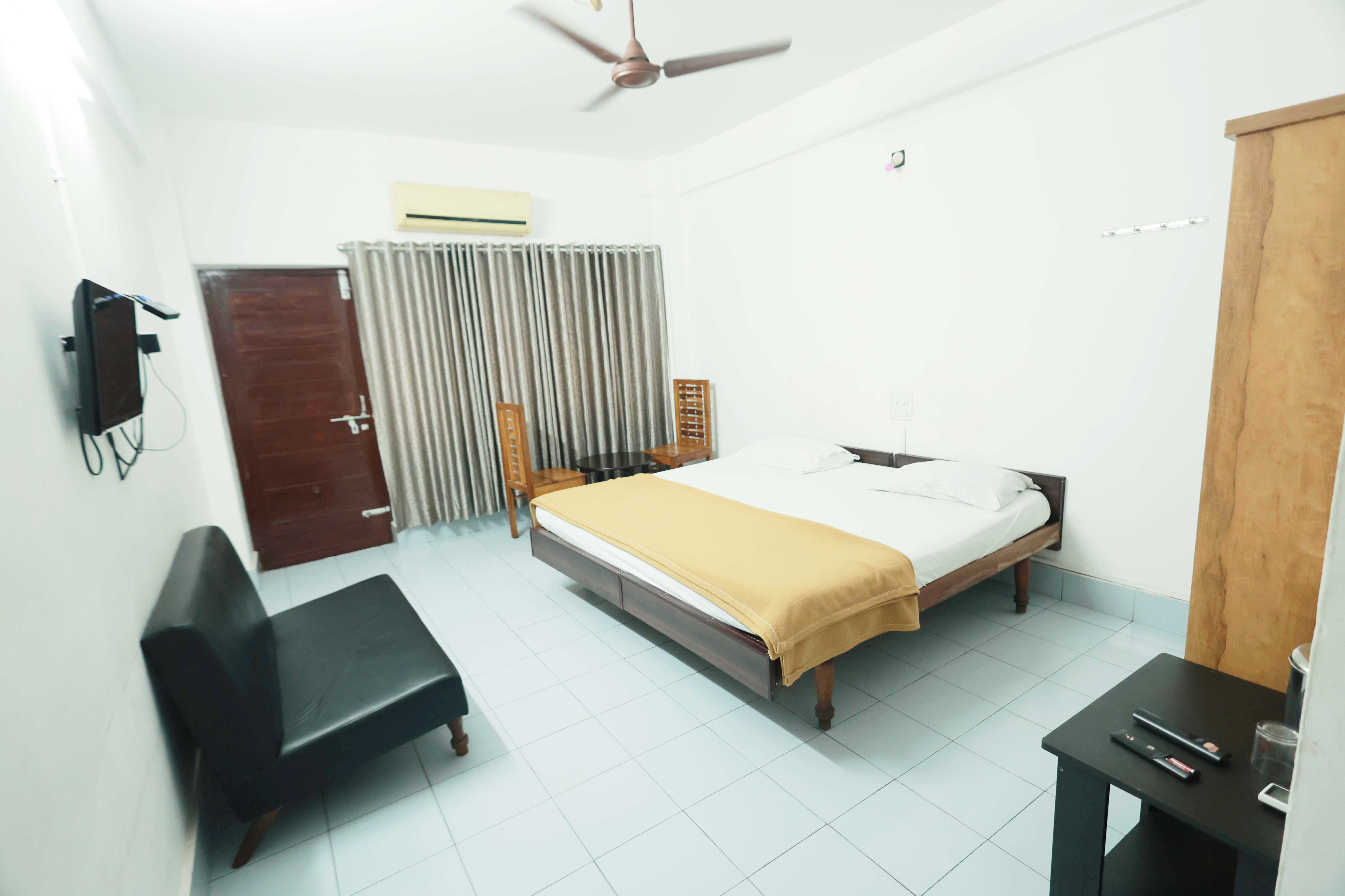 AC room with a wooden headboard and armchairs